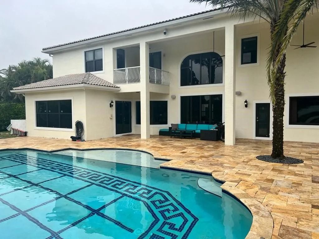 A large white house with a swimming pool in front of it