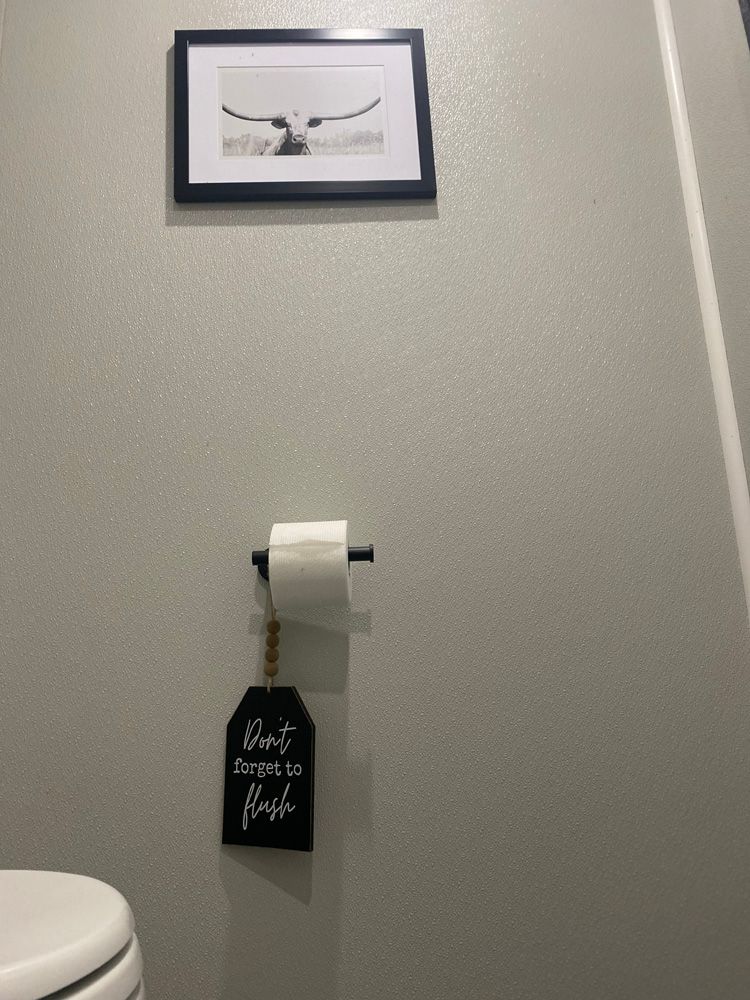 A toilet with a picture on the wall above it and a sign that says `` don t forget to flush ''.