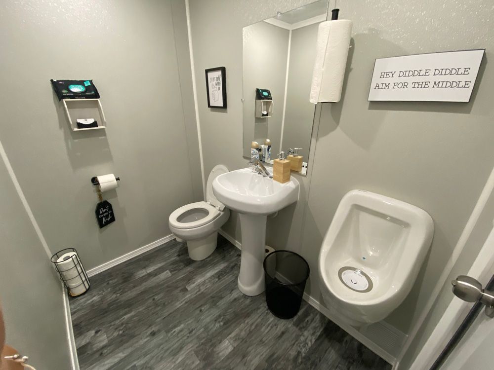A bathroom with a toilet , sink , urinal and mirror.