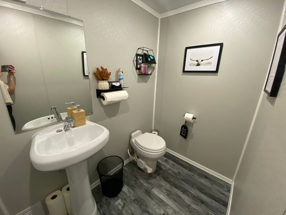 A bathroom with a sink , toilet and mirror.