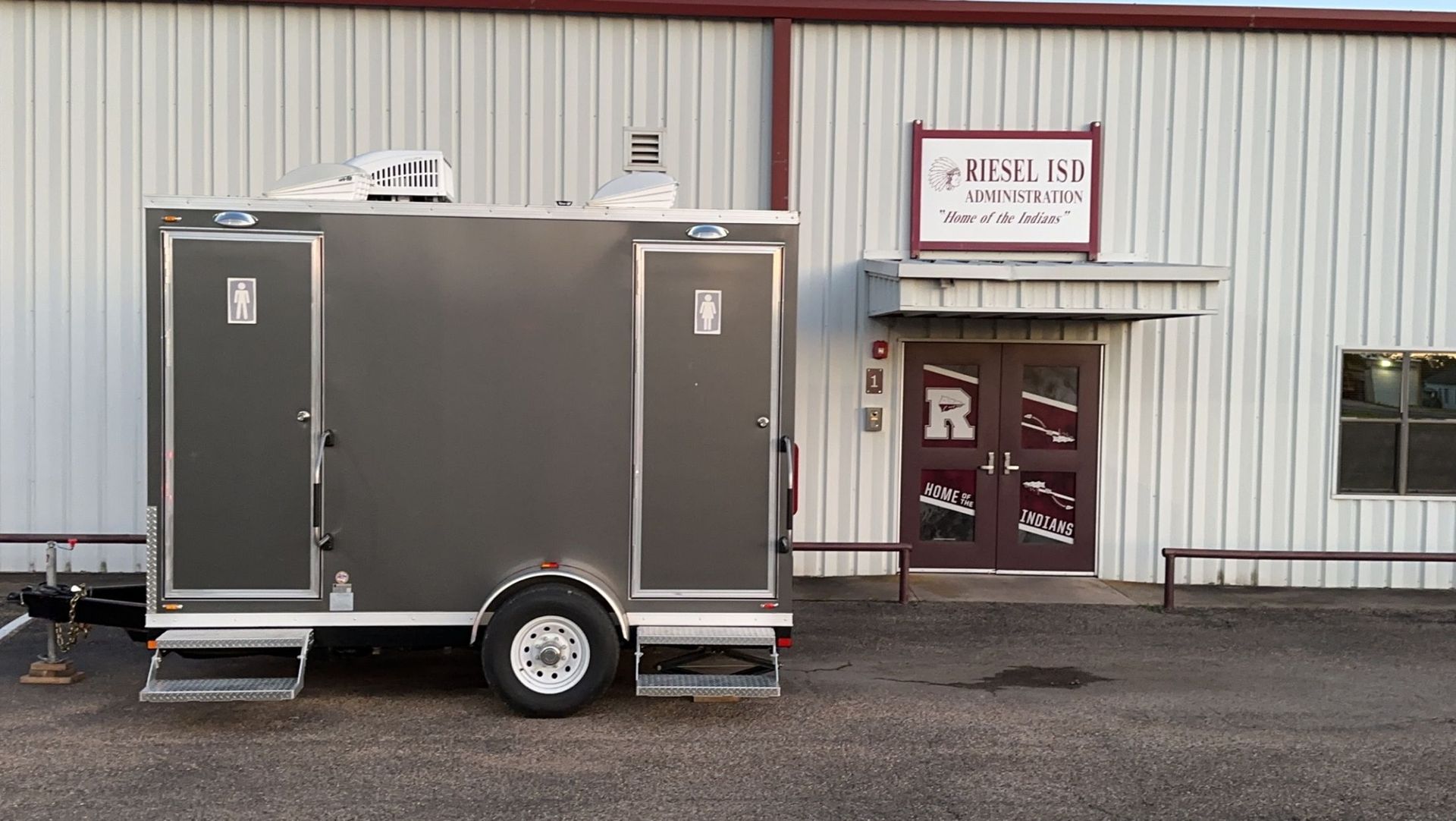 A trailer is parked in front of a building.