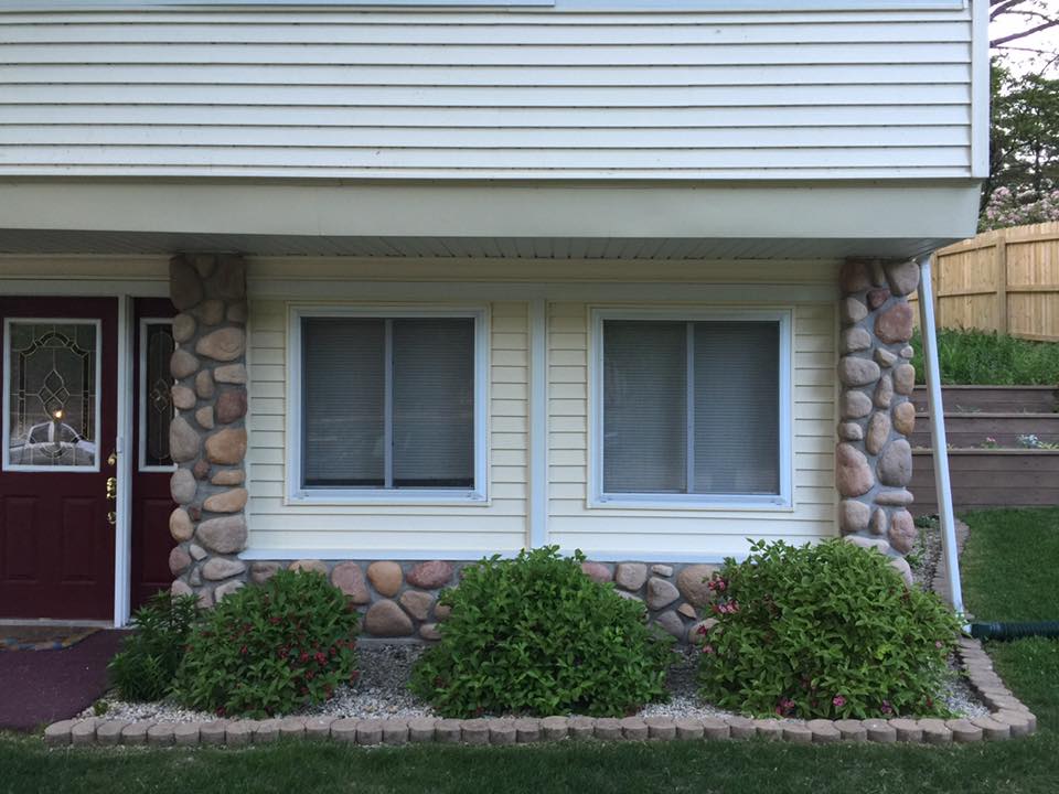 A white house with a red door and two windows