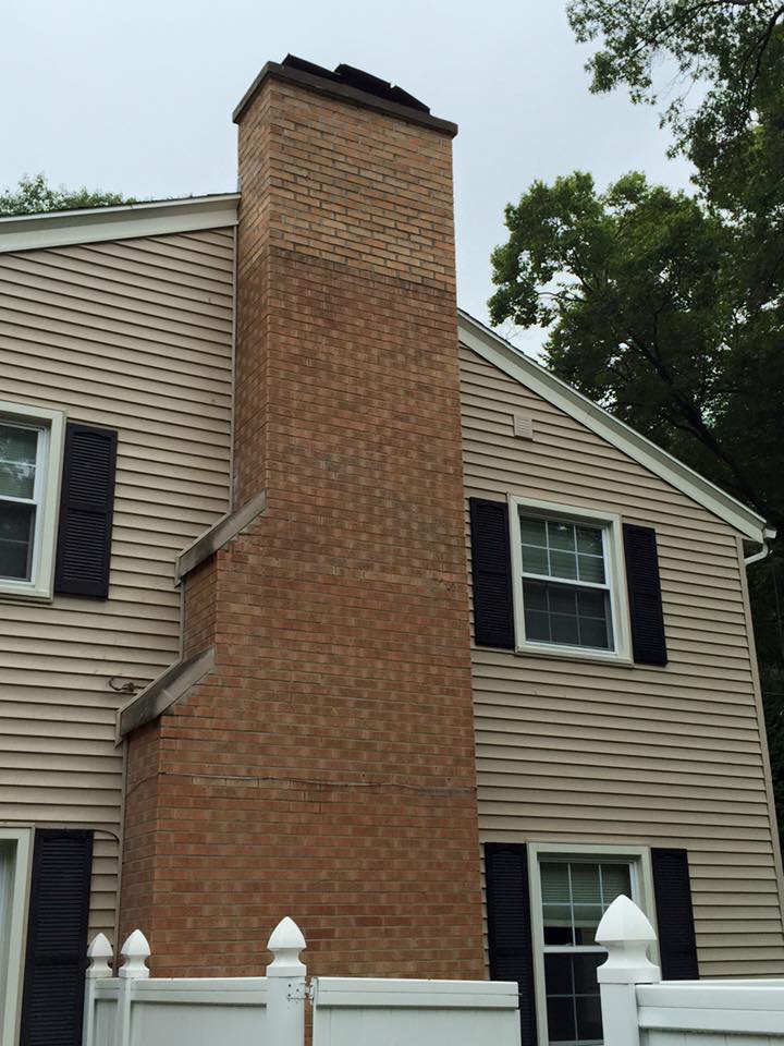 A large brick chimney on the side of a house