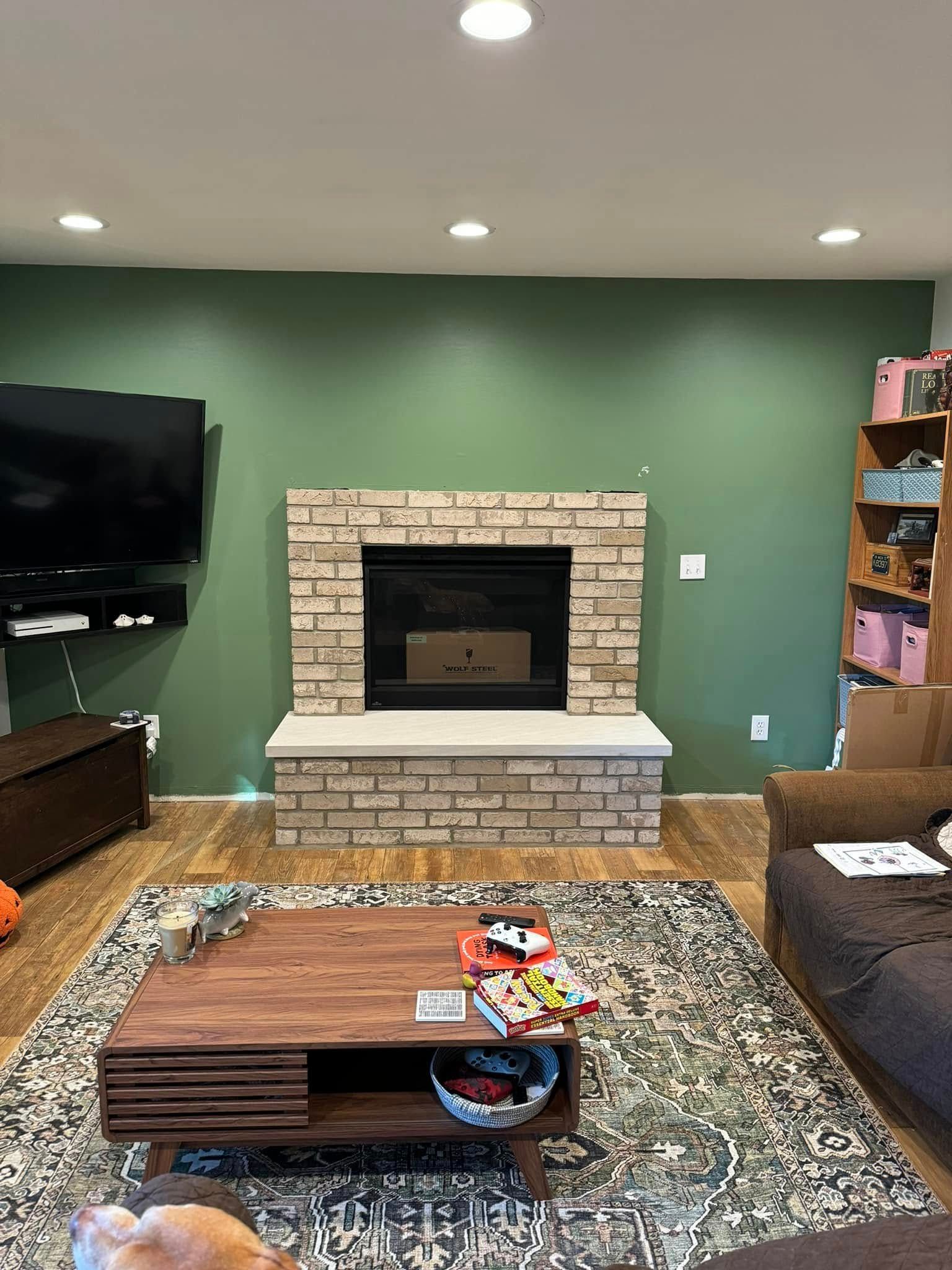 A living room with a fireplace , couch , coffee table and television.