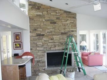 A living room with a fireplace and a green ladder