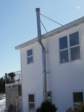 A white house with a stainless steel chimney on the side