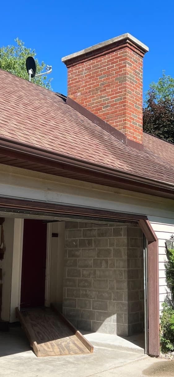 There is a brick chimney on the roof of the house.