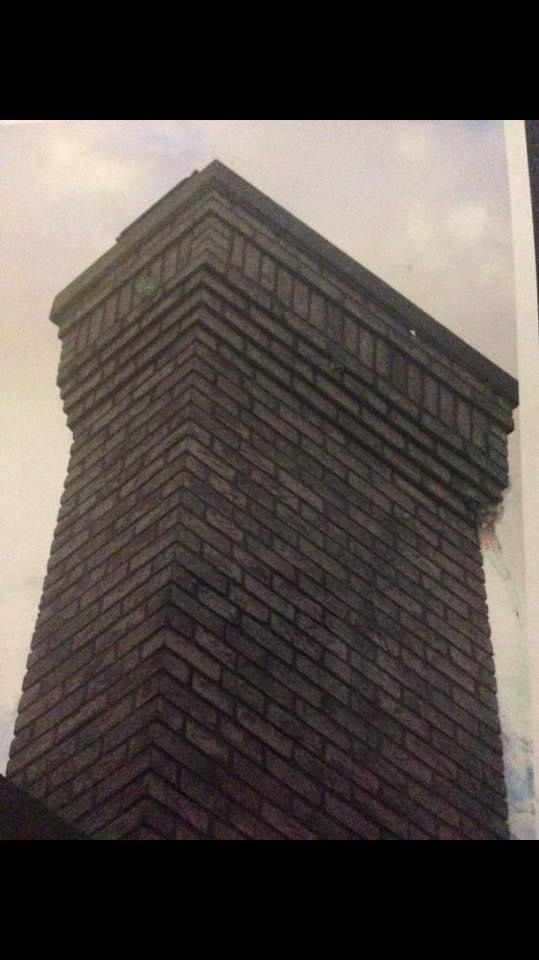 A black and white photo of a brick chimney on top of a building.