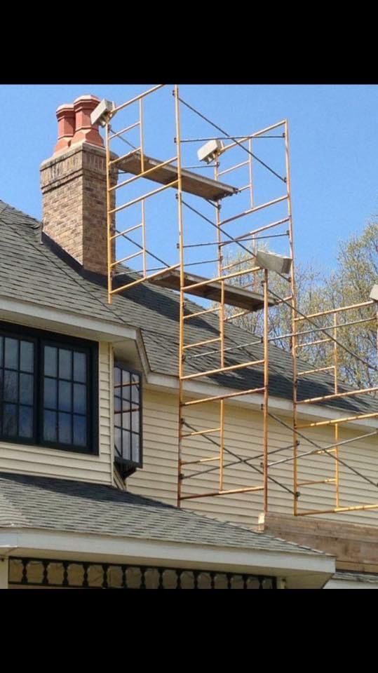 A house with a chimney and scaffolding on the roof