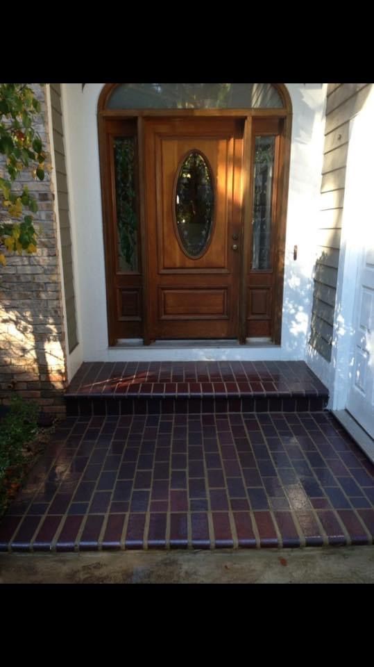The front door of a house with a brick walkway leading to it.