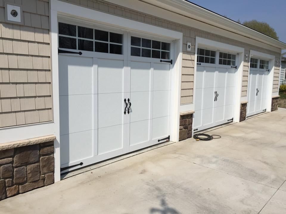 A row of white garage doors on a house