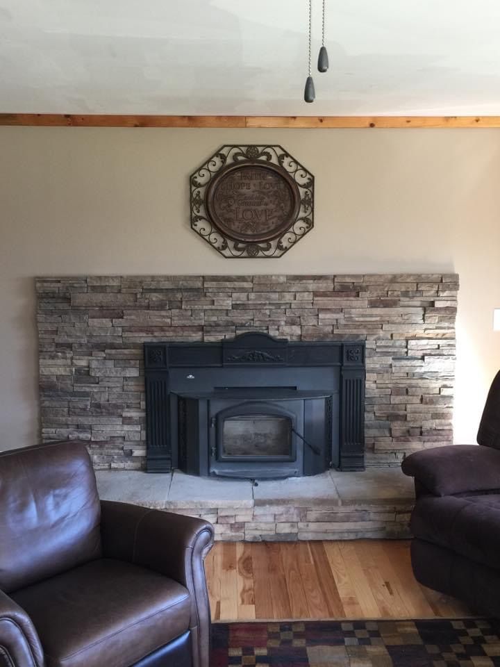 A living room with a fireplace and two chairs