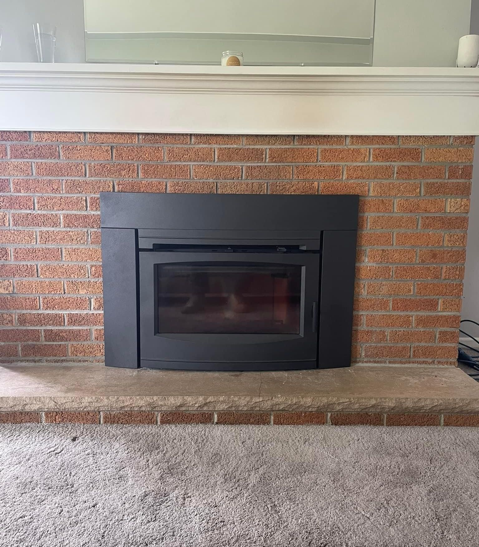 A brick fireplace with a black fireplace insert