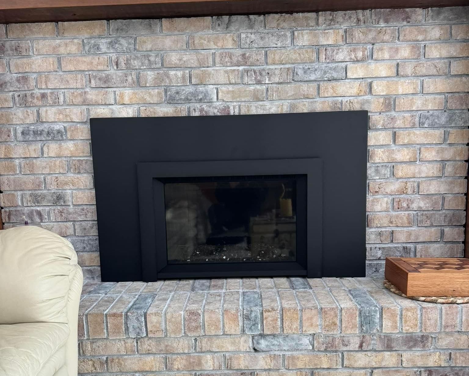 A fireplace in a living room with a black frame