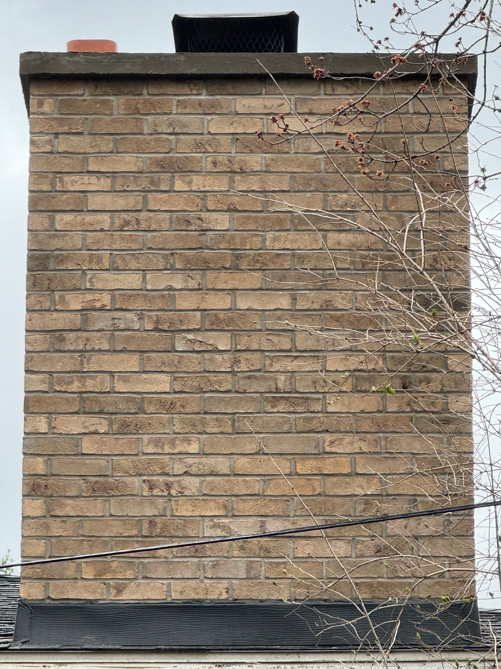 A brick chimney on the side of a building