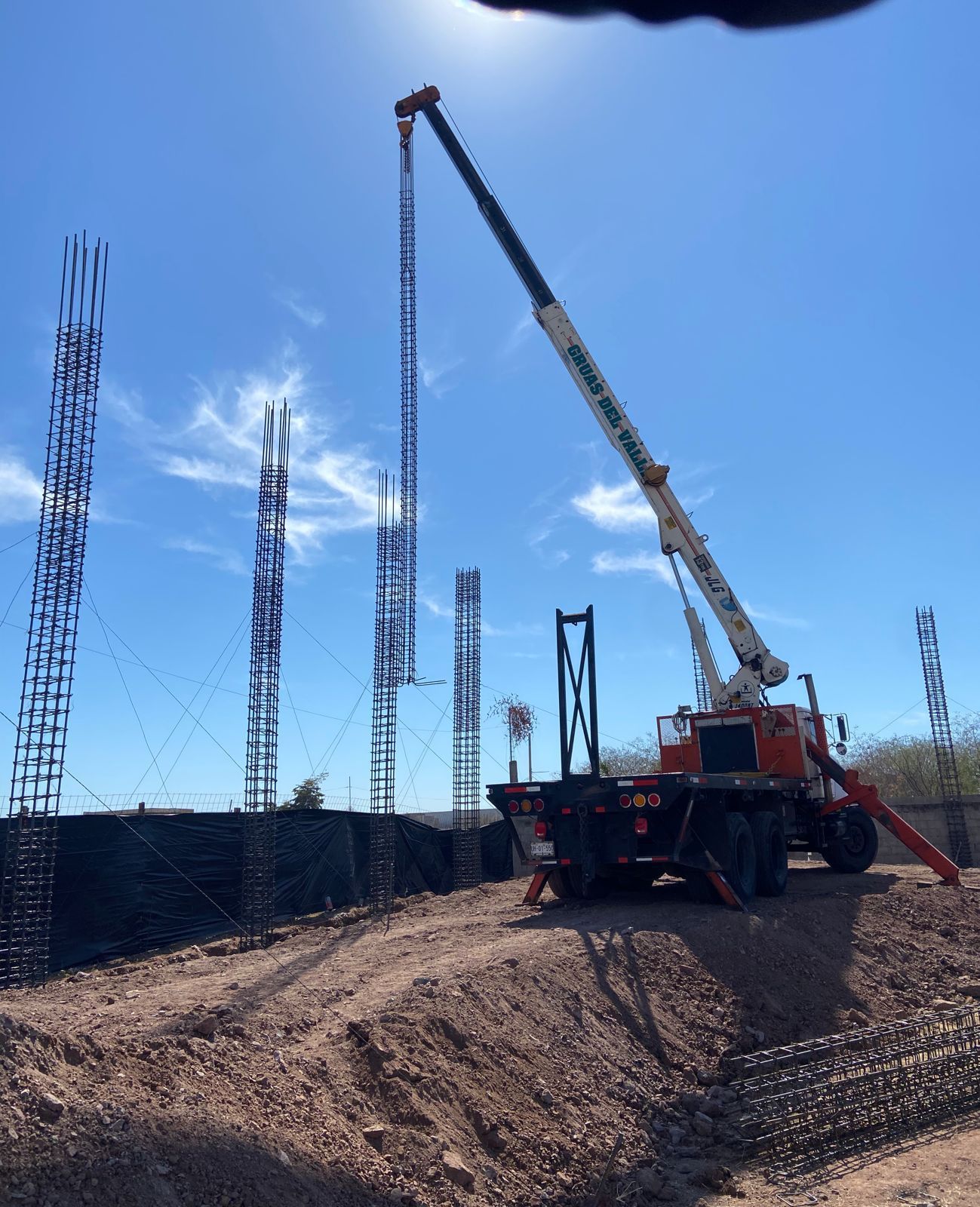 Una gran grúa se encuentra sobre un camino de tierra.