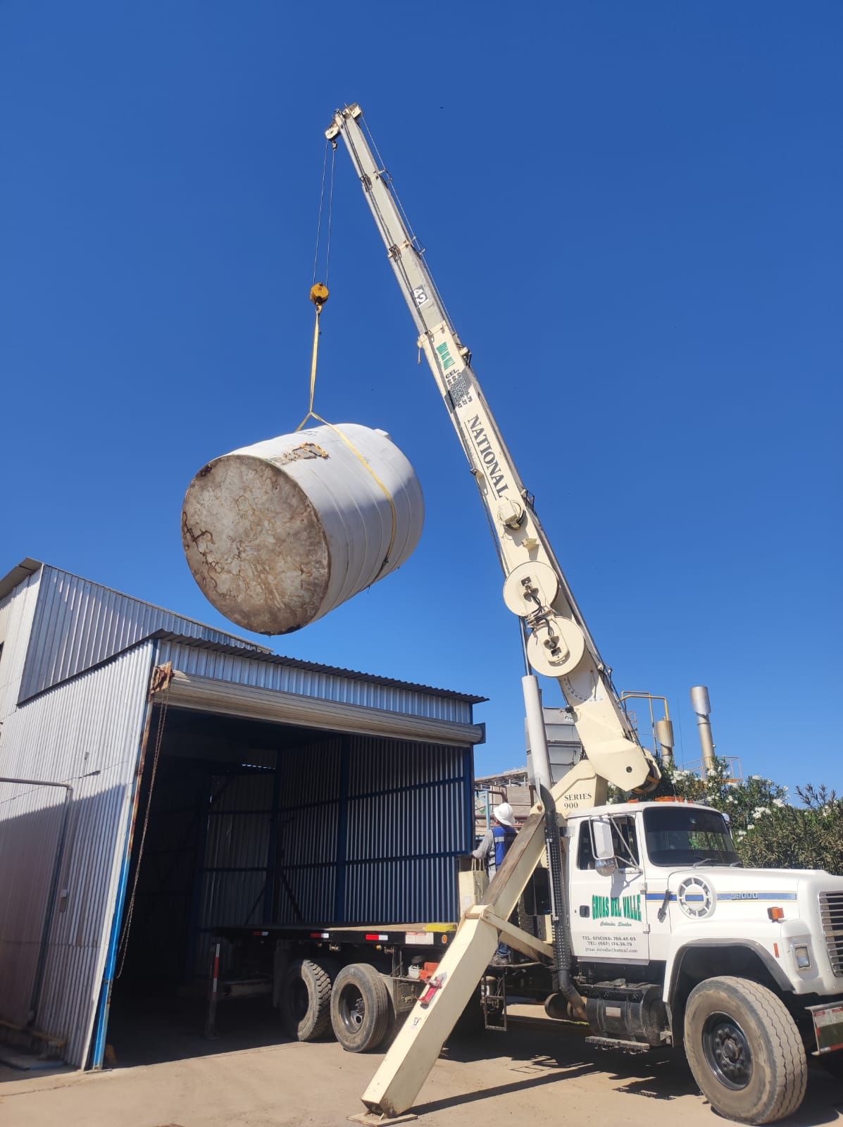 Un gran cilindro de hormigón está siendo levantado por una grúa.