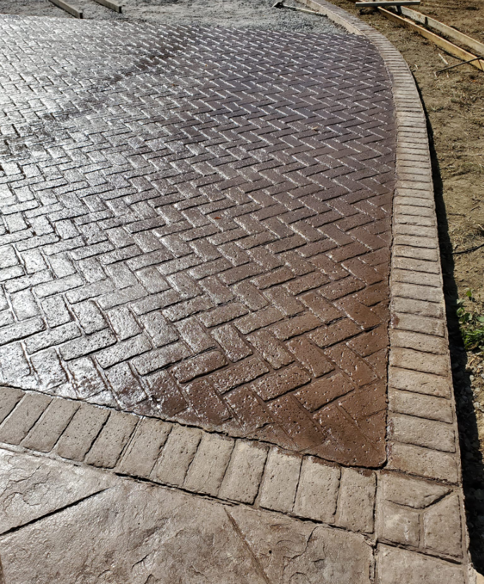 Stamped concrete patio with a brick pattern and border.