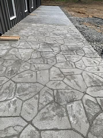 Gray stamped concrete walkway alongside a building.