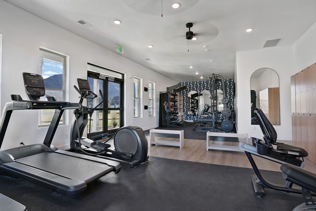 Indoor apartment gym with treadmills, a stationary bike, and weight equipment.
