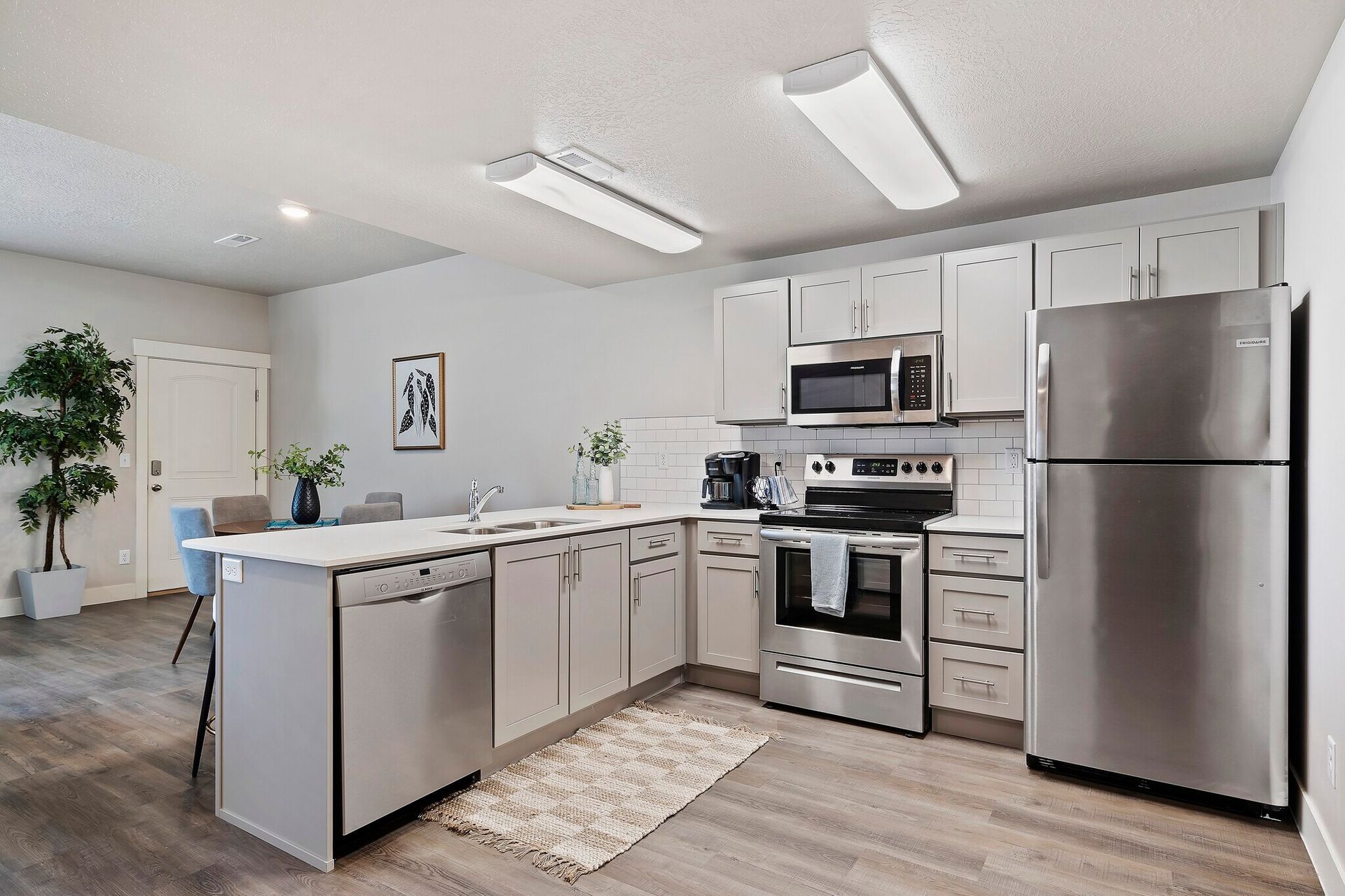Modern apartment kitchen with stainless steel appliances, white cabinetry, and an island.