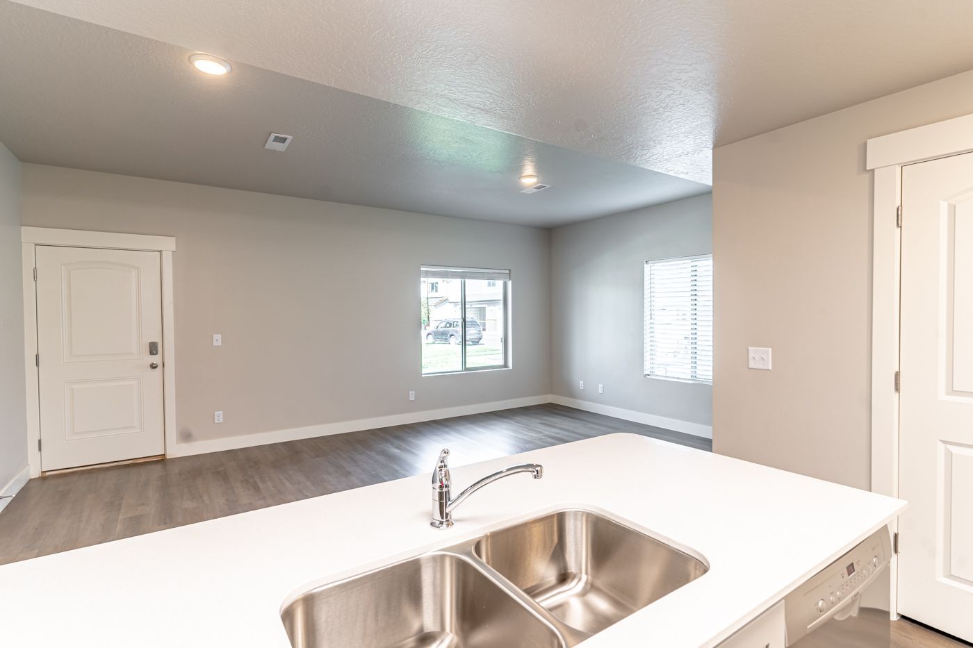 Open-concept kitchen with a double-basin sink island overlooking a bright living area.
