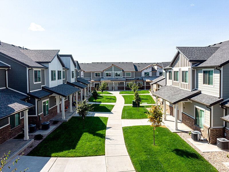 Aerial view of townhomes with a central green walkway.