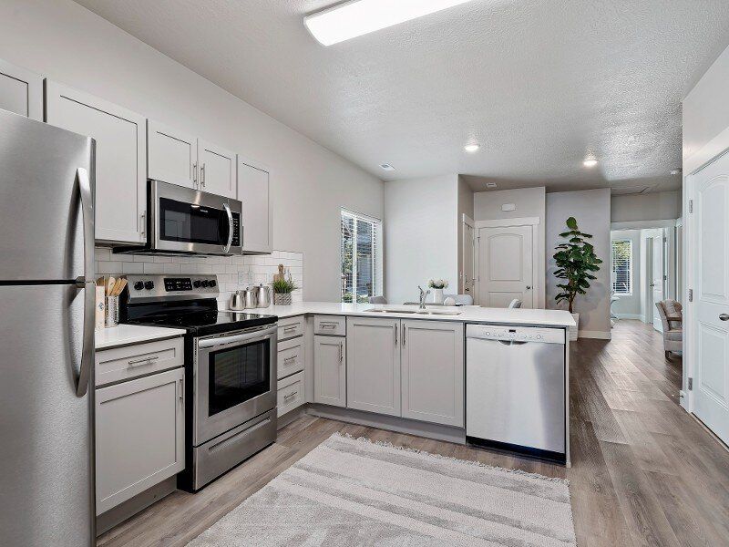 Kitchen with stainless steel appliances, light gray cabinets, and a white countertop.
