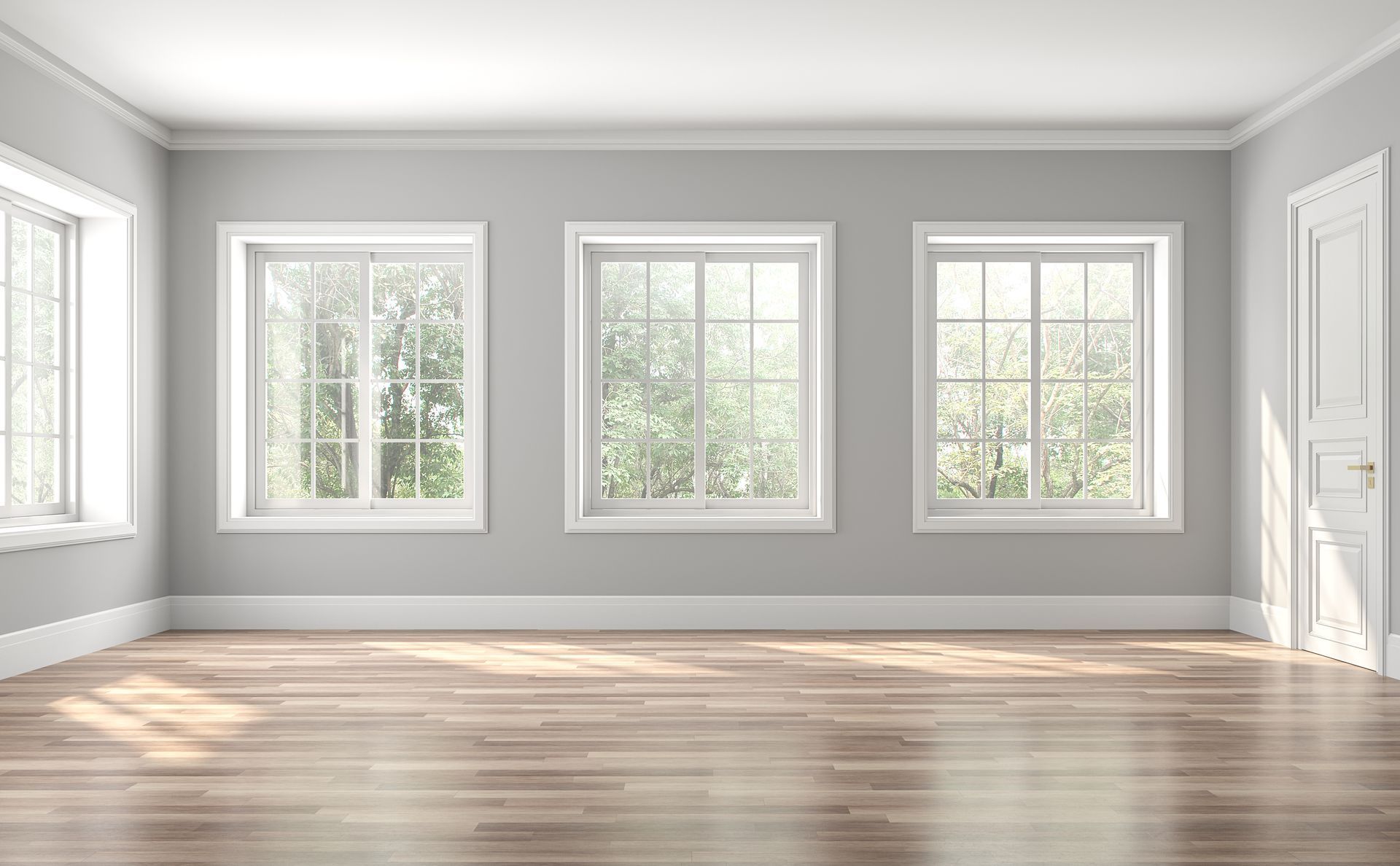 Empty room with wood floor, three windows, and a door. Light gray walls.