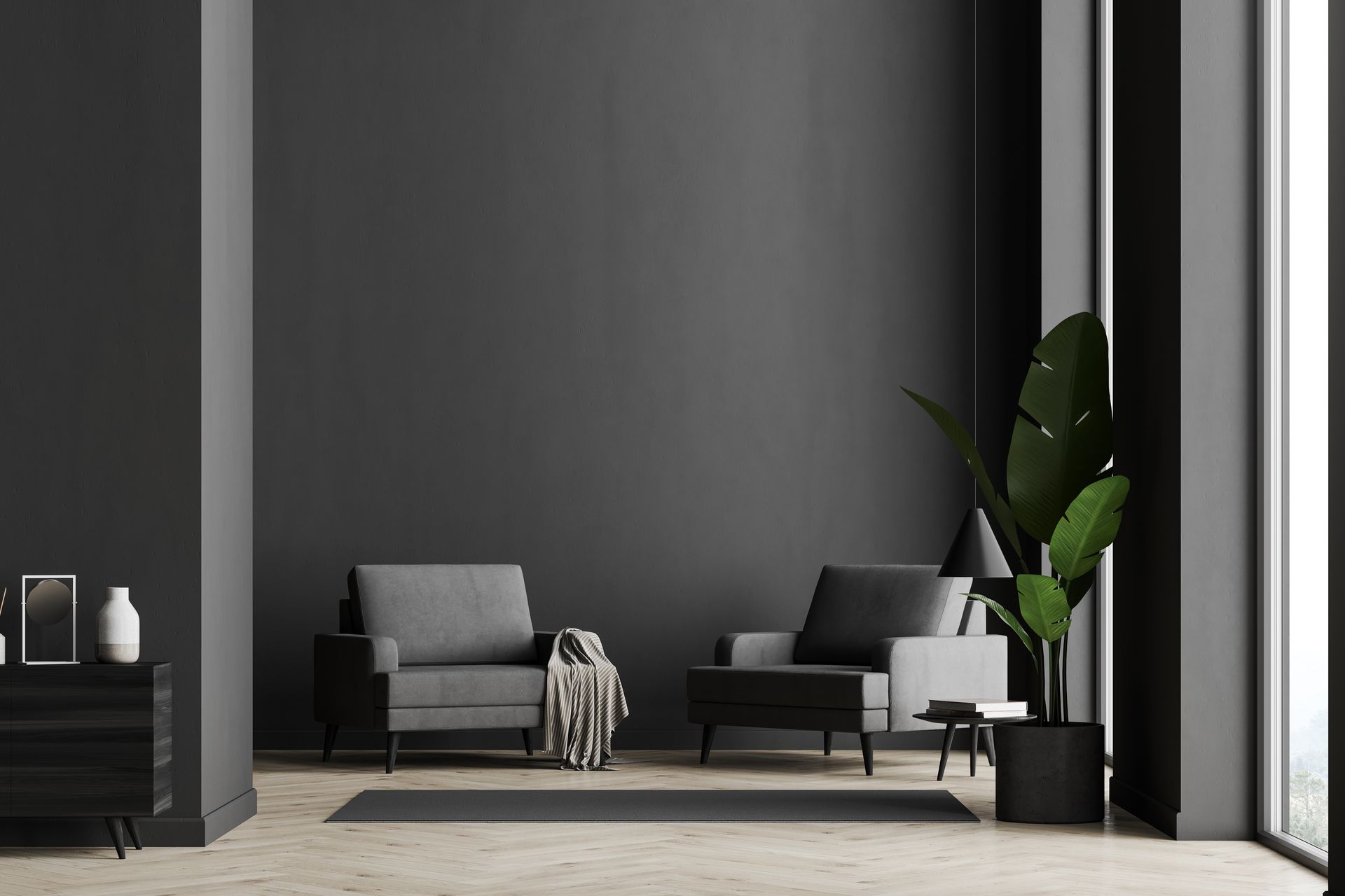 Two gray armchairs face a dark gray wall, plant, and side table in a modern living room.