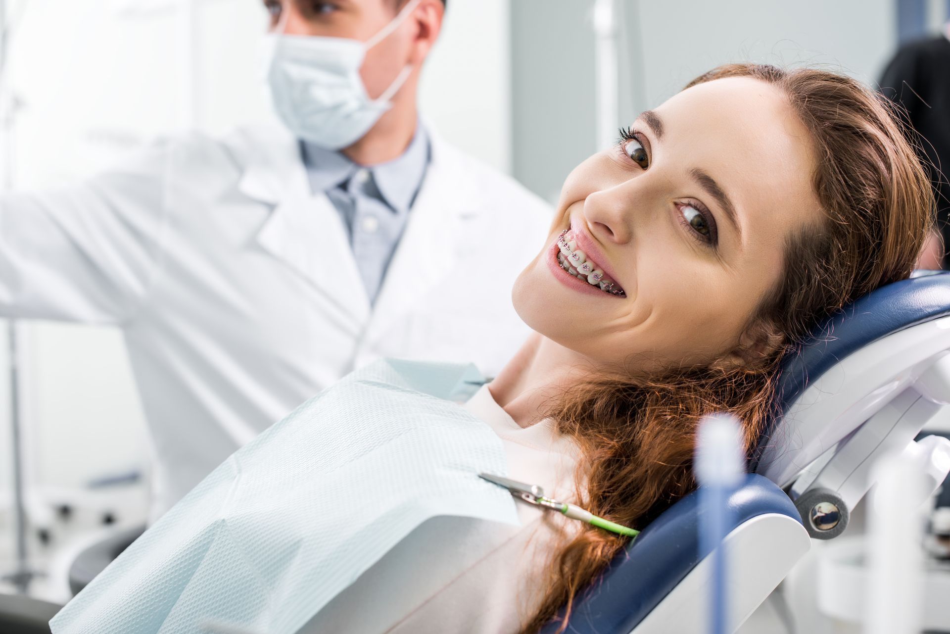 A close-up of a woman in braces during an examination of her teeth with a dentist.