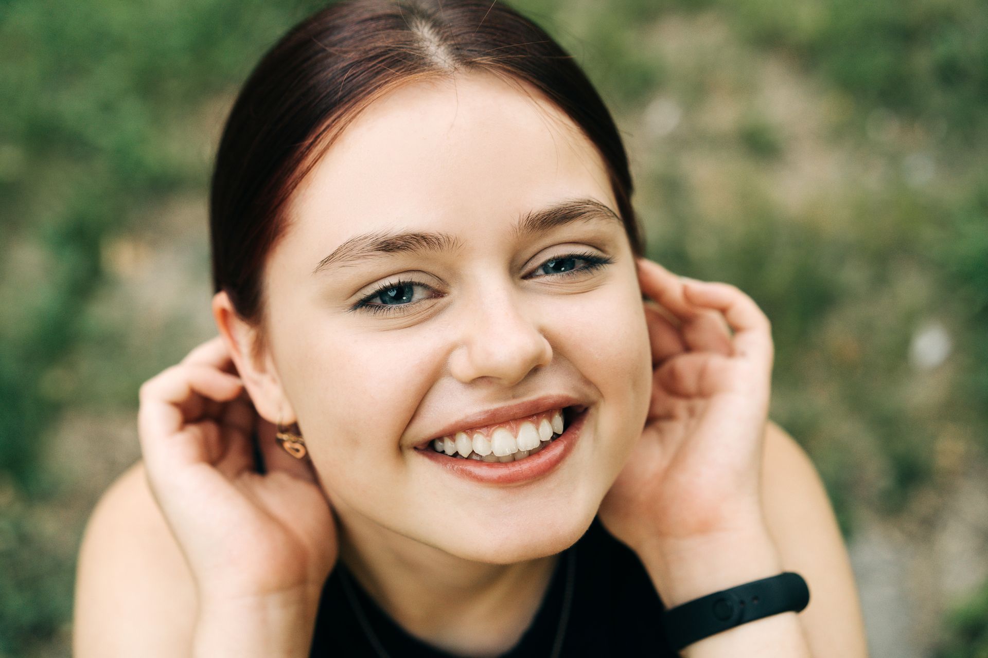 Close-up of person's mouth with silver braces on the upper and lower teeth; pink lips and visible gums.