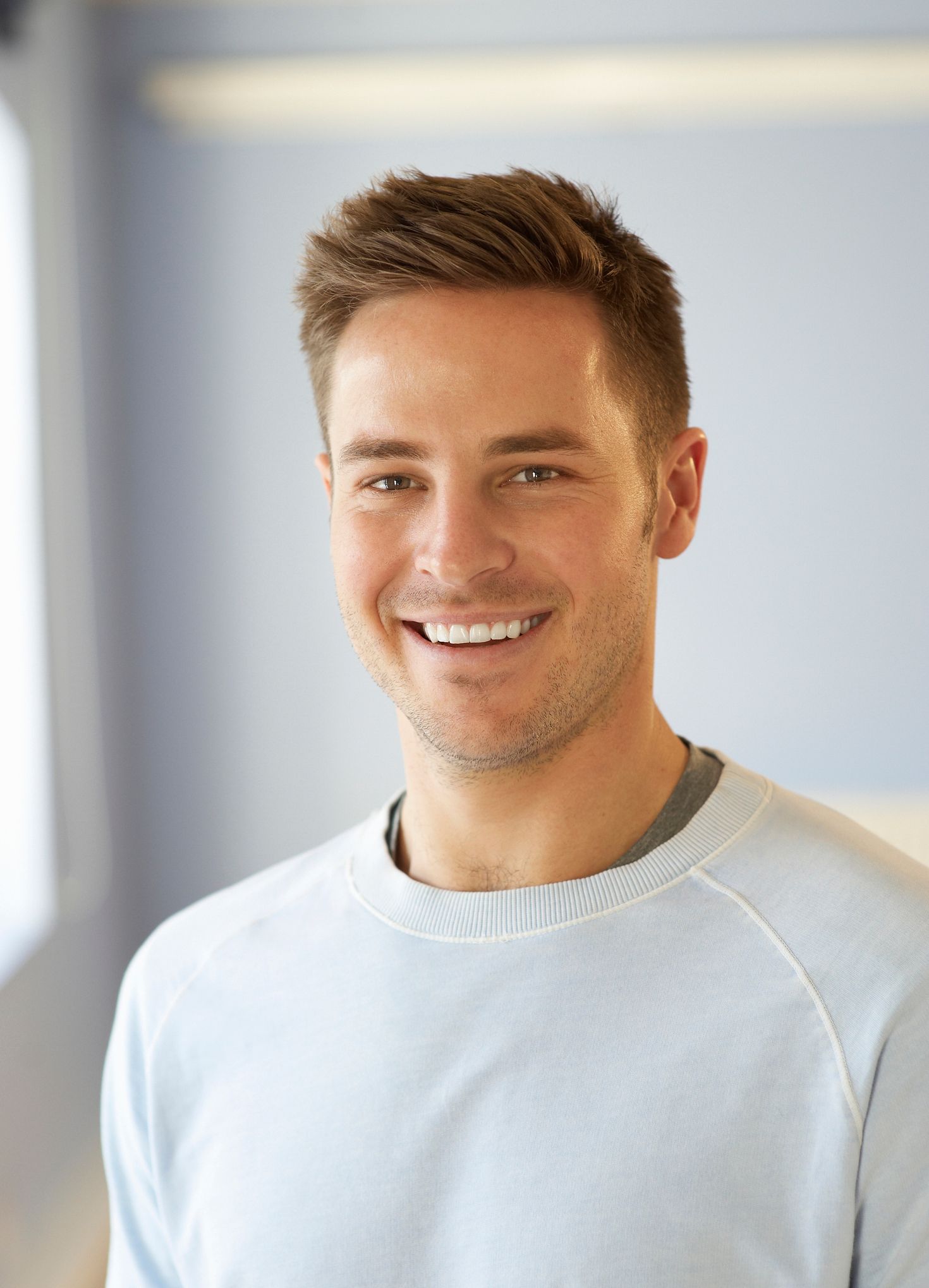 Woman in dental chair looking at teeth in mirror, dentist in gloves examining.