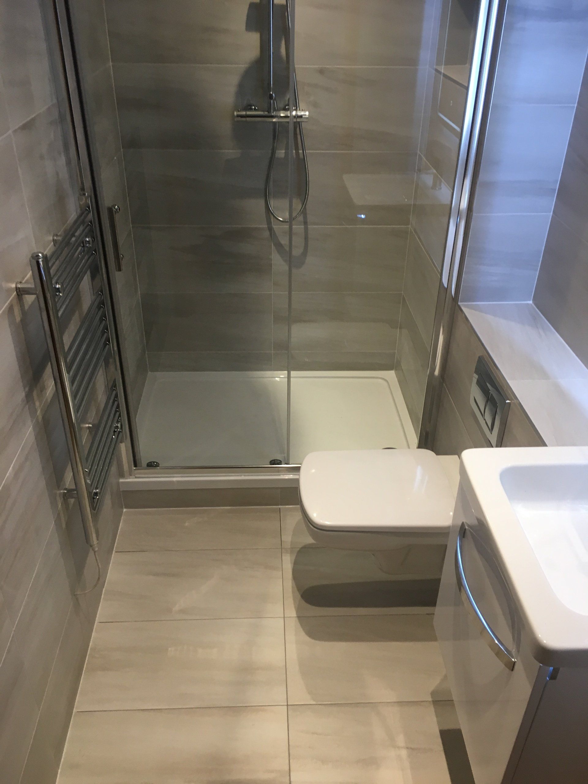 Beautiful ensuite bathroom grey tileswhite wall hung vanity unit big shower