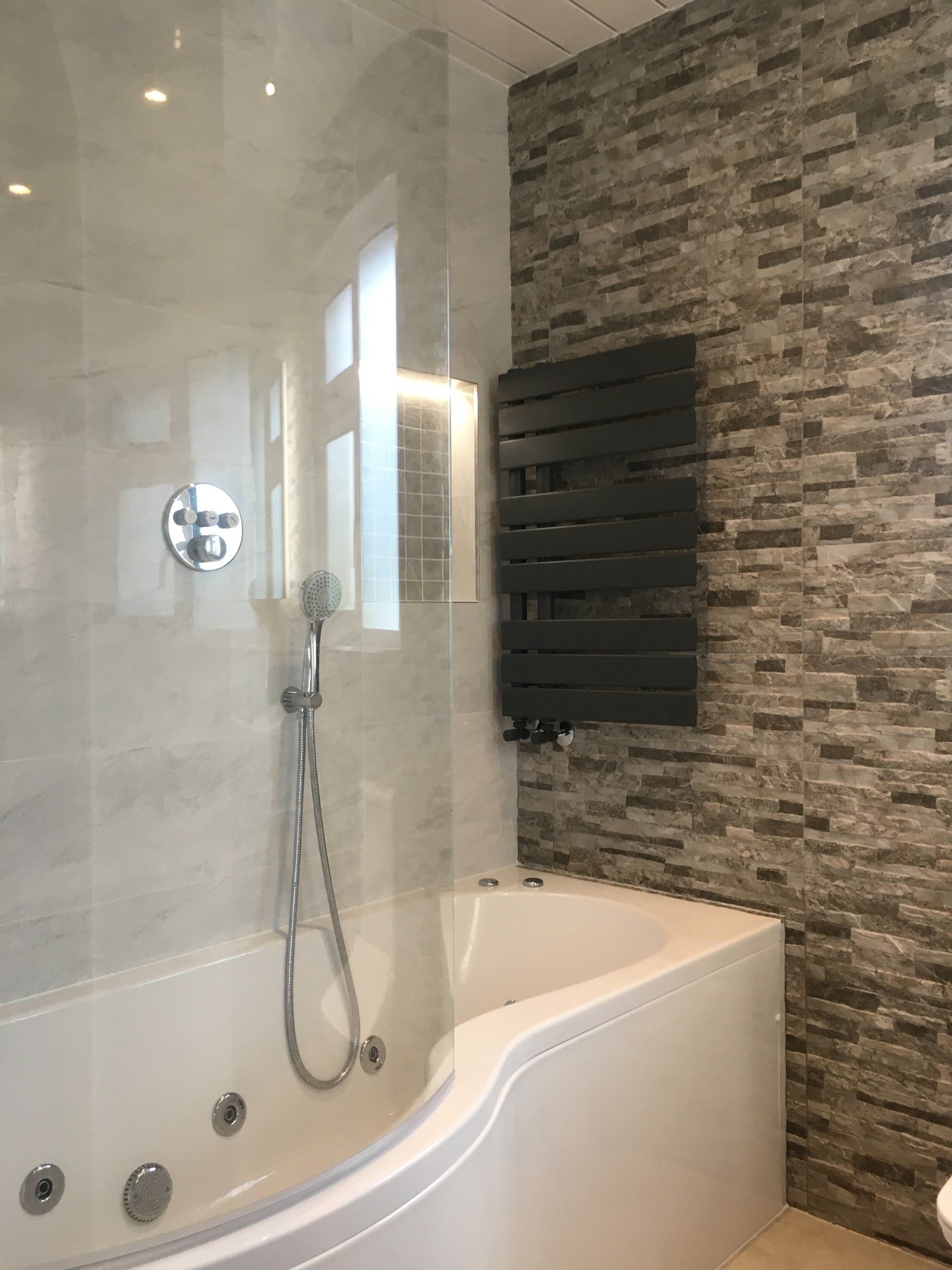 Bathroom stone effect tiles cladding P shaped jacuzzi bath anthracite heated towel rail