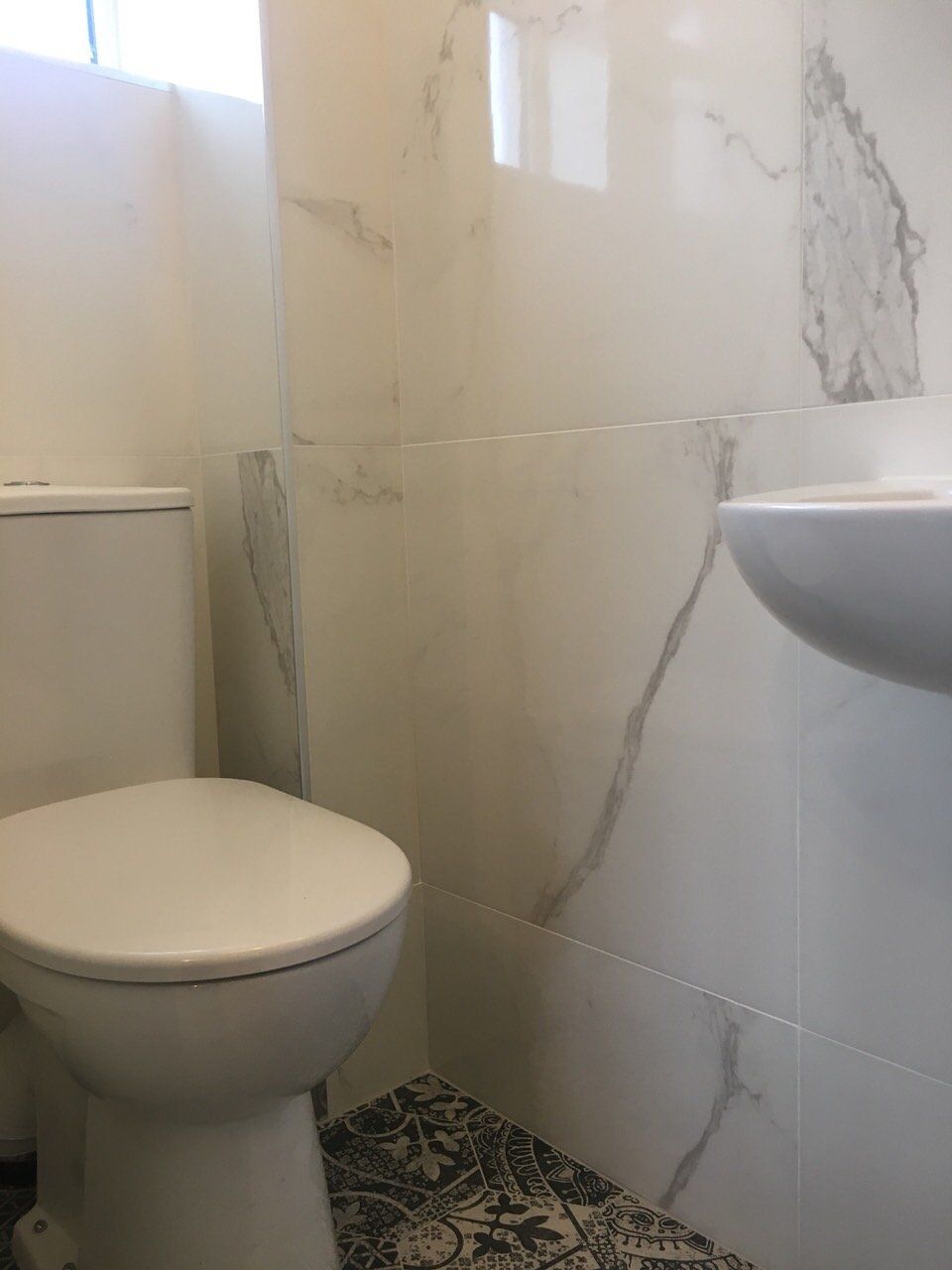 Small ensuite bathroom marble effect tiles and toilet
