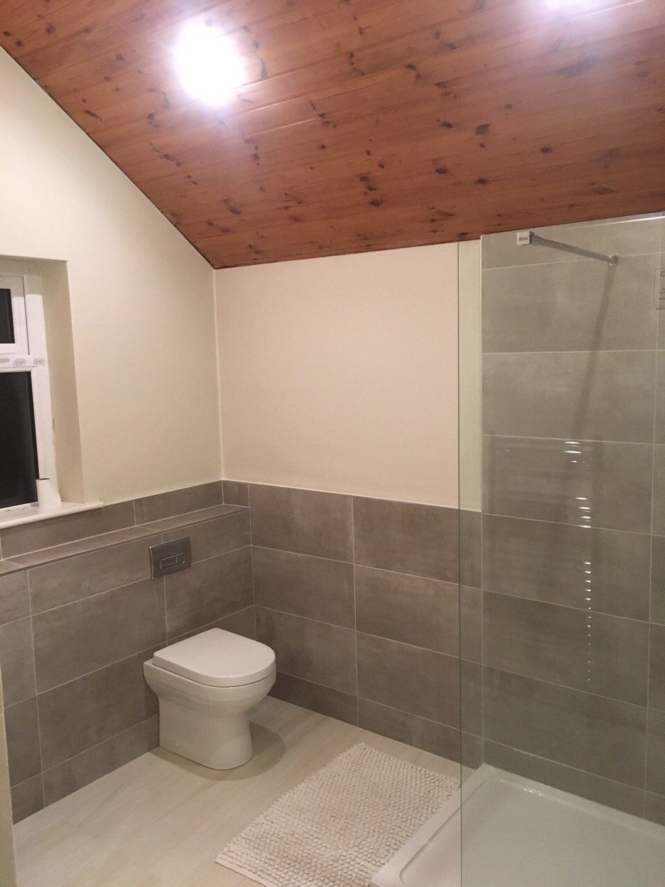 Big bathroom grey tiles wooden ceiling walk in shower light grey floor tiles