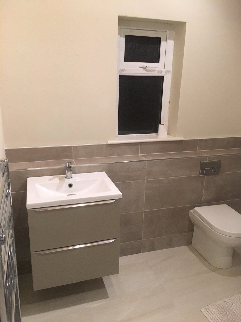 Big bathroom half way tiling grey tiles grey wall hung vanity unit and back to wall WC with concealed cistern
