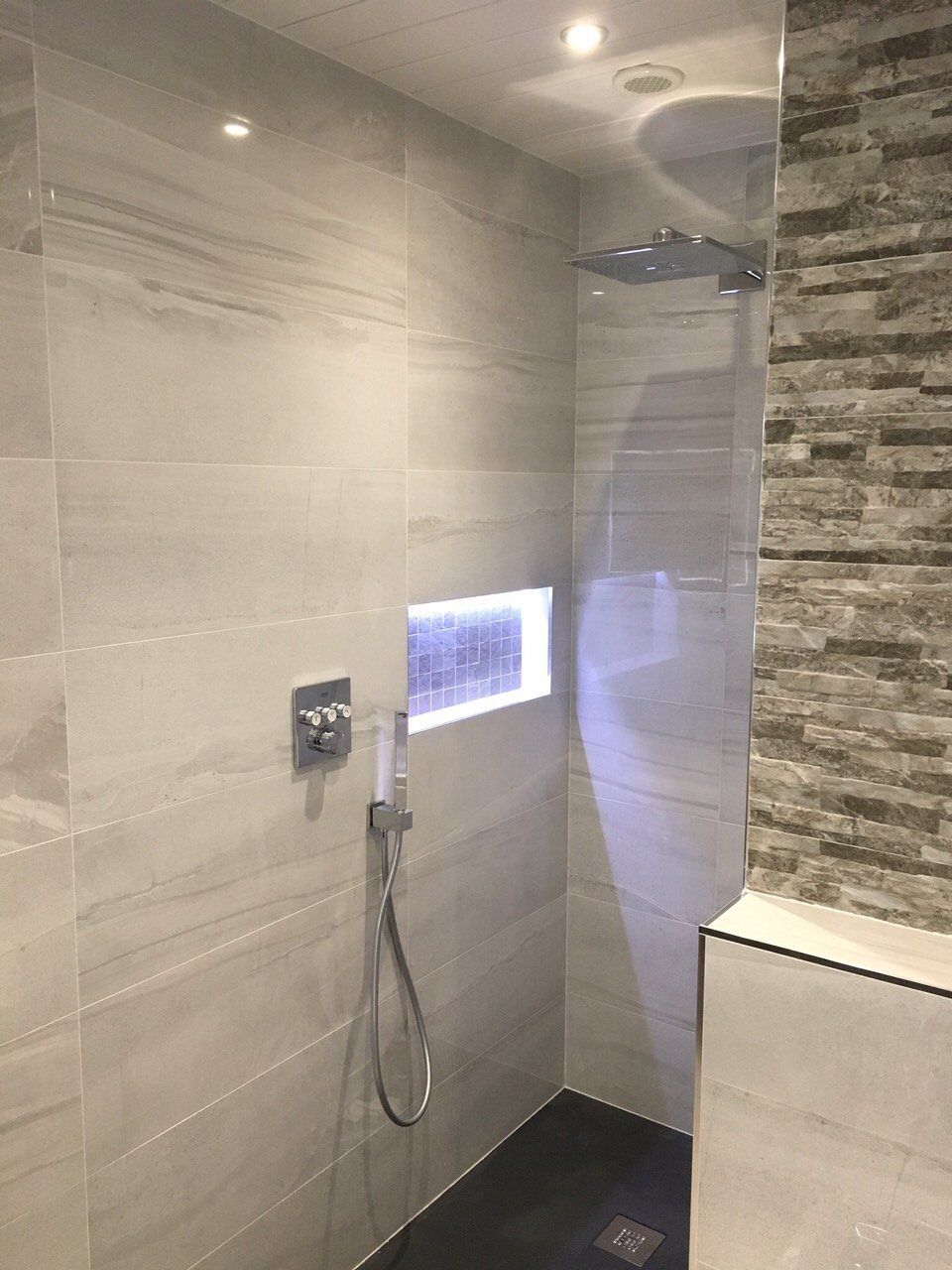 Bathroom with grey tiles modern walk in shower and recessed shelf