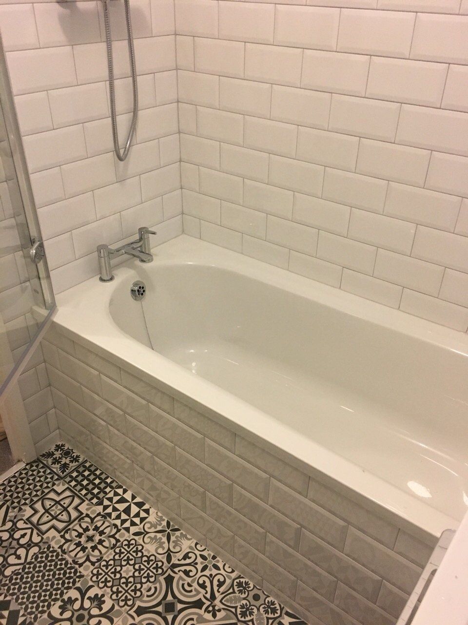 Bathroom white subway tiles and black and white monochrome Morroccan patterned floor tiles and bath