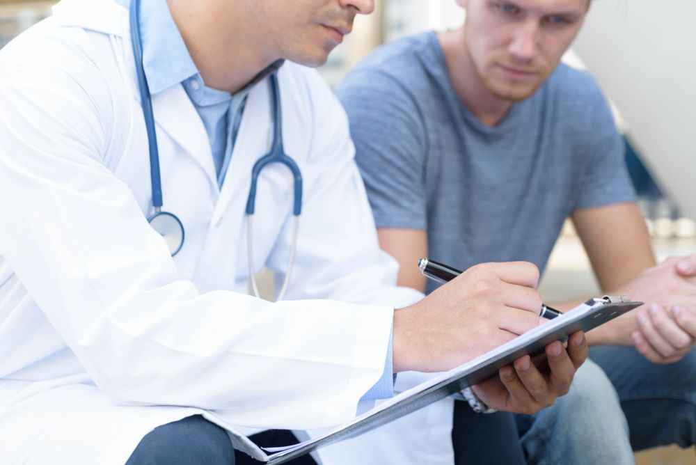 A Doctor is Talking to a Patient While Holding a Clipboard — Collis Care In Dundowran, QLD
