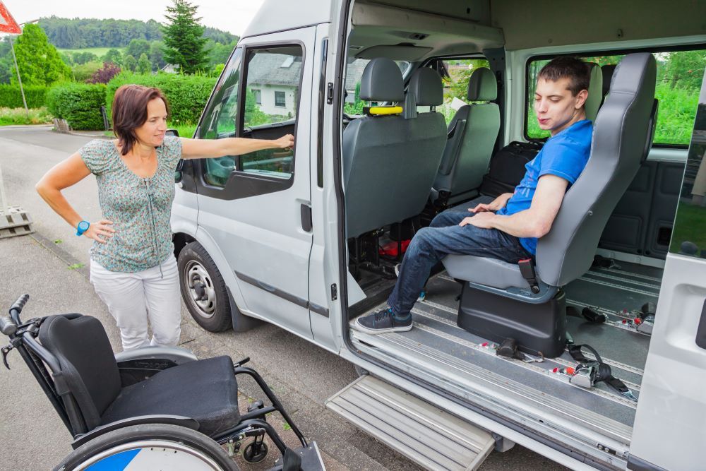 A Woman is Standing Next to a Man in a Wheelchair in a Van — Collis Care In Dundowran, QLD