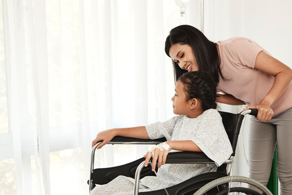 A Woman is Standing Next to a Little Girl in a Wheelchair — Collis Care In Dundowran, QLD
