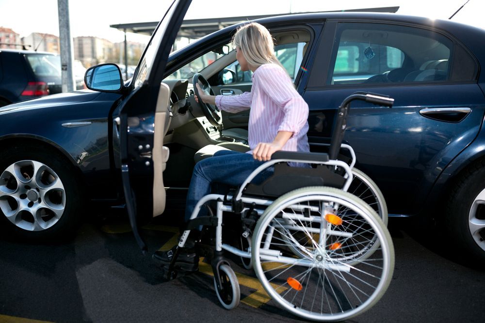 A Woman in a Wheelchair is Getting Into a Car — Collis Care In Dundowran, QLD