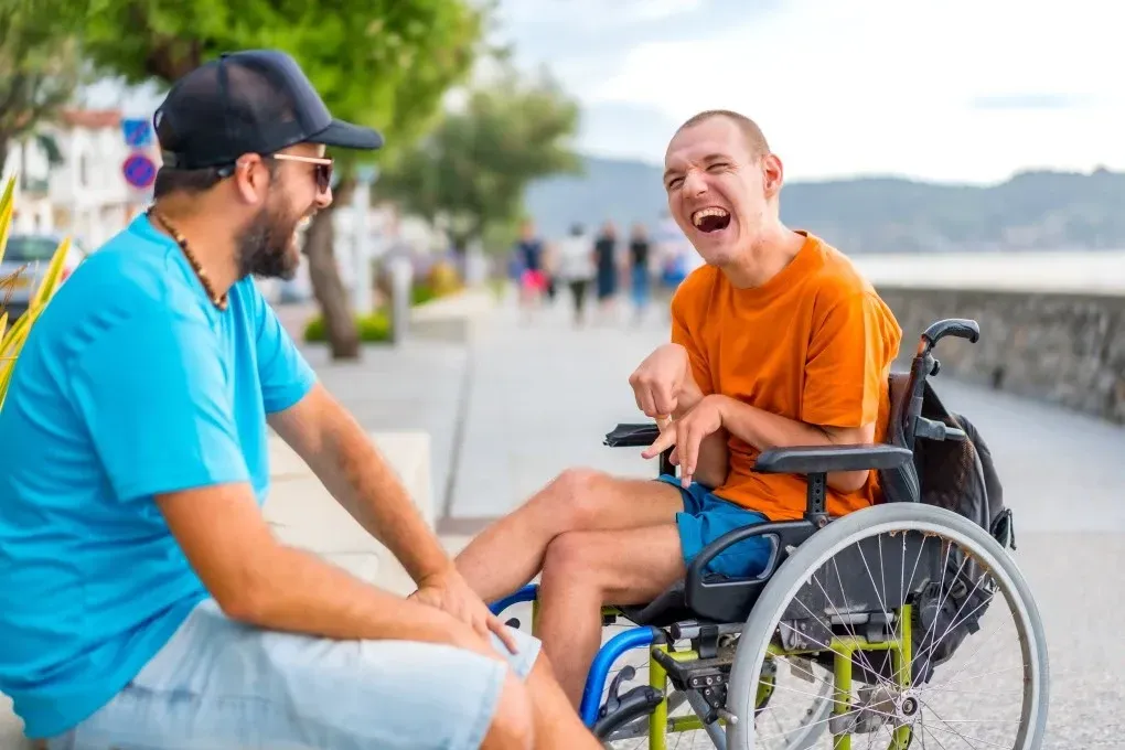 A Man is Sitting Next to a Man in a Wheelchair — Collis Care In Dundowran, QLD