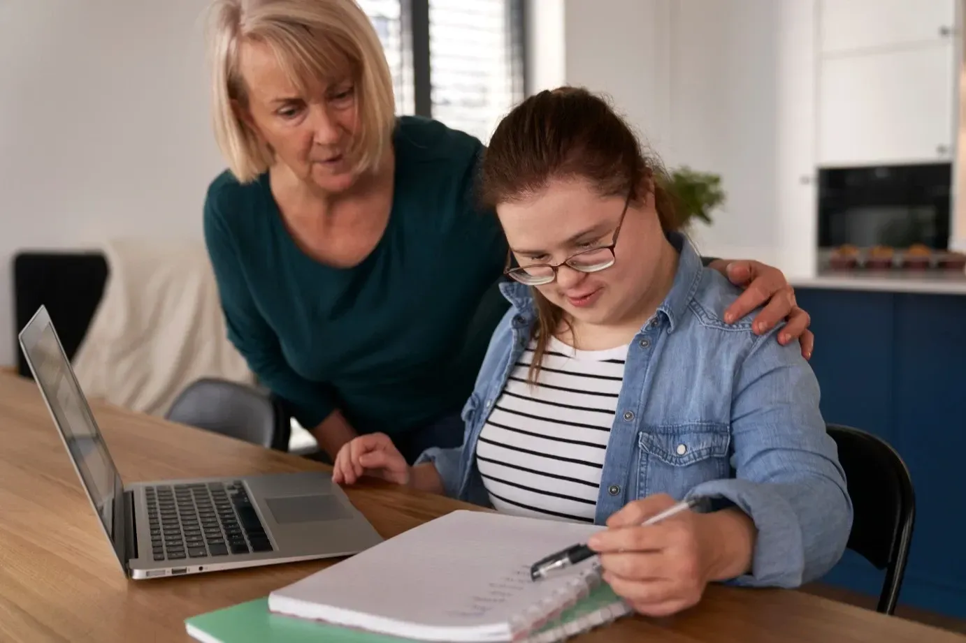 A Woman is Helping a Young Girl With Her Homework — Collis Care In Dundowran, QLD