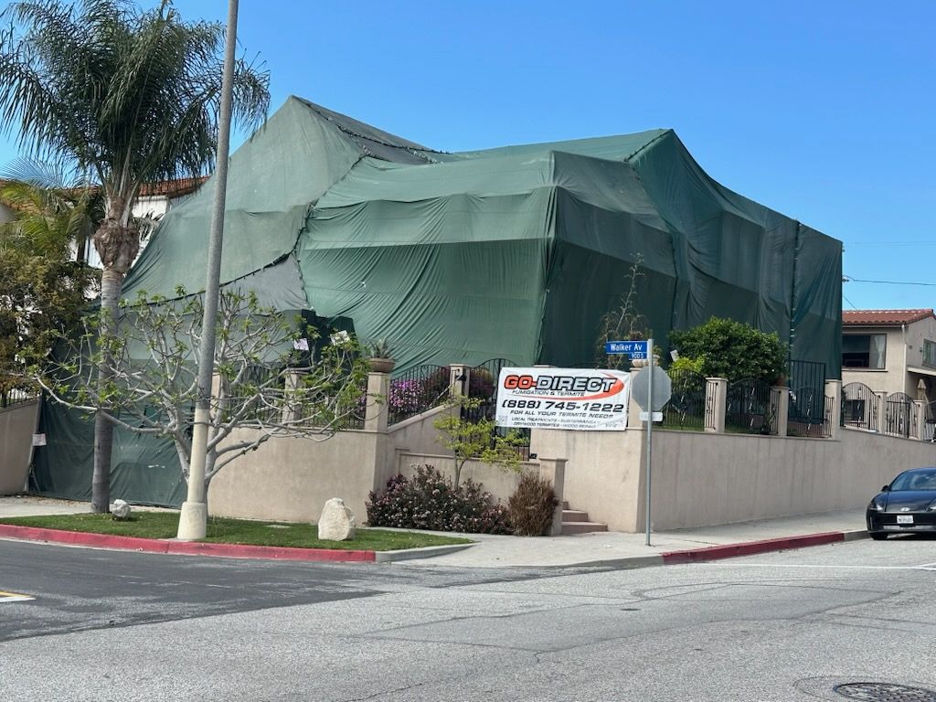 House covered in green tarps for fumigation. 