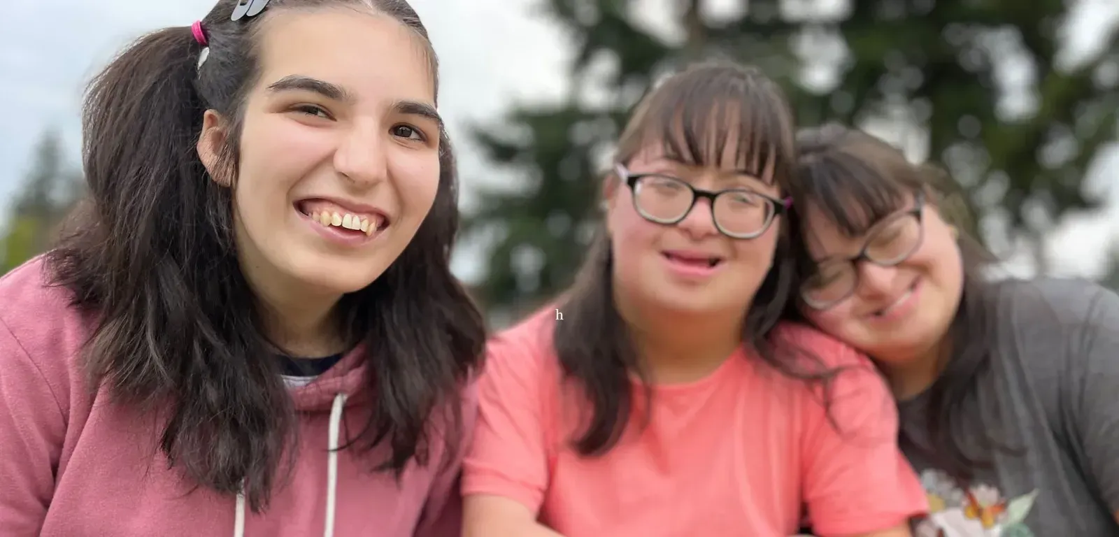 Hand holding string lights against a sunset.