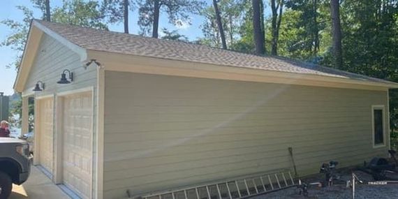 A garage with a ladder and a car parked in front of it.