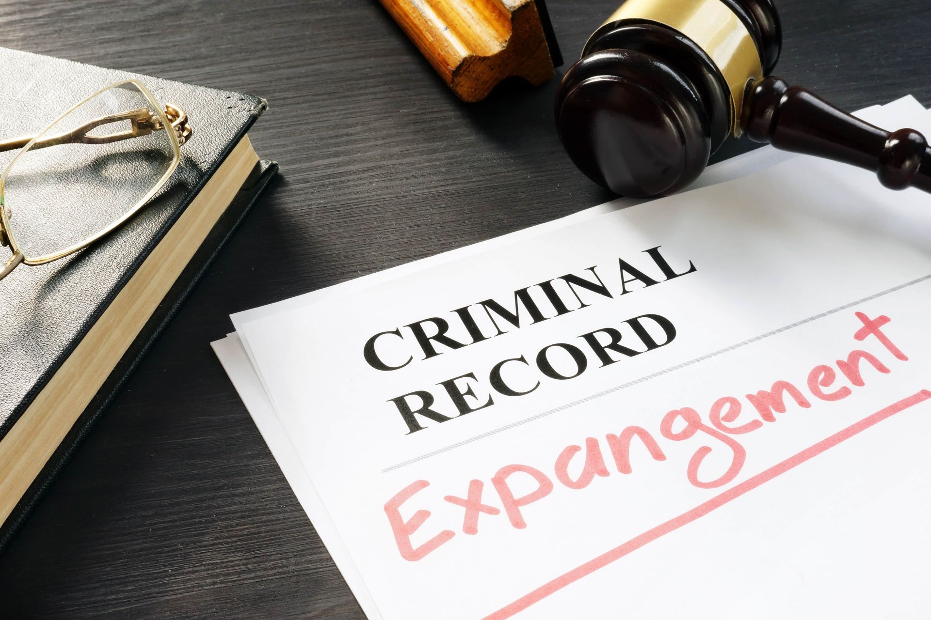 Criminal record expungement document beside a judge’s gavel and books on a desk